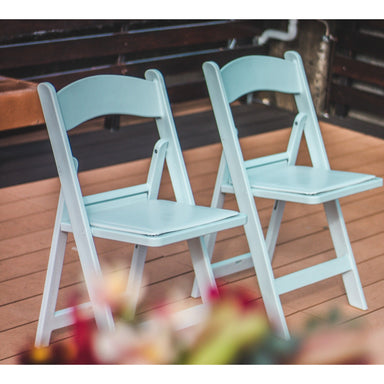 McCourt Gala White Resin Folding Chair With Padding Two Side By Side At Wedding